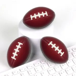 Detail view of brown PU foam rugby stress balls displayed on white stand with keyboard.