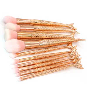 Primer plano detallado del juego de brochas de maquillaje sirena en oro rosa con textura.