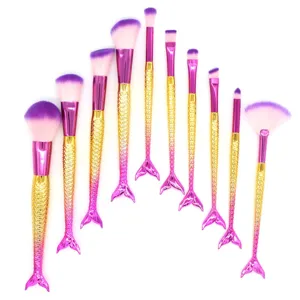 Set de 10 brochas de maquillaje de sirena con cerdas moradas y mangos de cola de pez dorados.