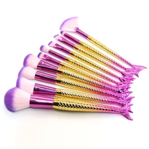 Set de 10 brochas de maquillaje de sirena vista detallada, cerdas moradas y mangos dorados.