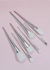 Detail view of a 7-piece makeup brush set with silver handles and soft white bristles.