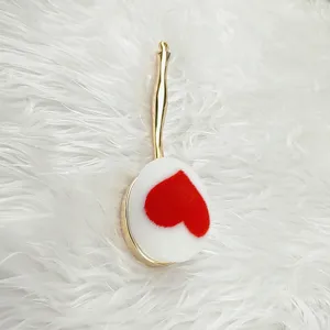 Nahaufnahme eines Zahnbürsten-Make-up-Pinsels mit Herzmuster und edlem goldenen Griff.