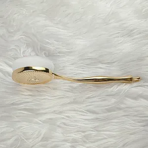 Nahaufnahme eines tragbaren Make-up-Pinsels mit goldenem Griff und weissen Borsten.