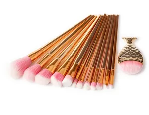 Detailed view of mermaid makeup brush set with gold handles and soft pink gradient bristles.