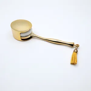 Detailansicht des goldenen Pinsel mit glänzendem Metallgriff, weichen Borsten und gelber Quaste.