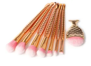 Detailed view of the gorgeous mermaid makeup brush set featuring sparkling gold fish scale handles.