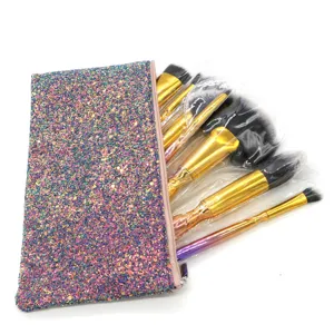 Detailansicht des Glitzer Make-up-Pinsel-Sets mit funkelnder Tasche und goldenen Griffen.