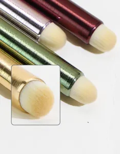 Close-up detail of makeup brush with metal handle and soft synthetic bristles for precision.