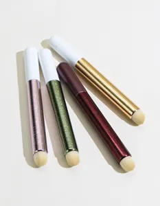 Detail view of portable makeup concealer brushes with colorful metallic handles and soft bristles.