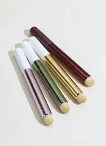 Detailed view of portable lip makeup brushes with metallic handles and soft round brush heads.