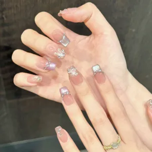 Exquisite handmade press-on nails featuring nude pink gradient cat eye and painted lilies.