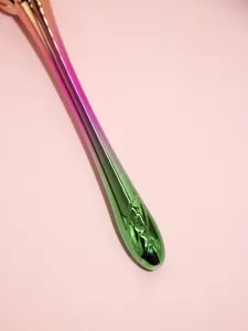 Detailed close-up view of gradient metallic makeup brush handle with glossy finish.