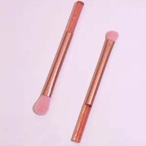 Detailed view of dual-ended pink makeup brushes with glitter handle and soft bristles set.