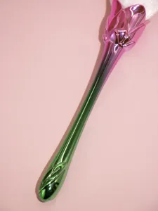Close-up detail of the gradient pink and green metallic rose makeup brush with soft bristles.