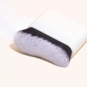 Professional large flat foundation brush with wavy dense bristles and white base stand.