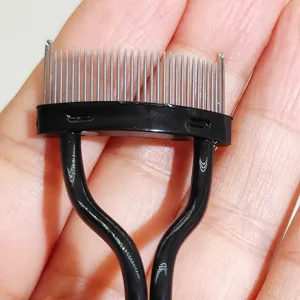 Primo piano del pettine per ciglia in metallo con manico nero per trucco preciso.