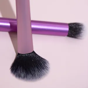 Close-up detail of dual pink makeup brushes featuring soft gradient black and white bristles.