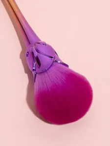 Gradient rose makeup brush detail showing soft pink bristles and metallic purple flower handle.