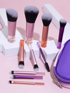 Detailed closeup view of portable mini makeup brush set featuring soft bristles and purple pouch.