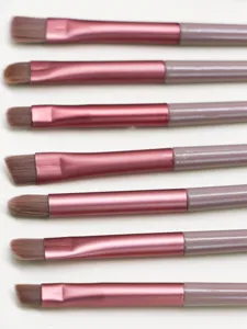Detailed view of makeup brushes set with pink ferrule and grey handle for eye makeup.