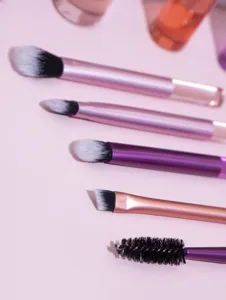 Detailed view of mini makeup brush set with metallic handles for daily travel use.
