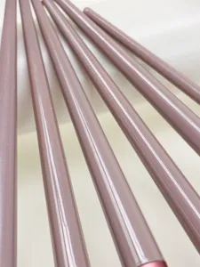 Detailed close up of soft makeup brush handles in mauve pink color, beauty tool texture.