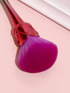 Close-up detail of gradient purple soft bristle makeup brush with metallic pink rose handle.