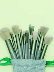 Detailed view of a complete 13-piece green makeup brush set with soft bristles for face.