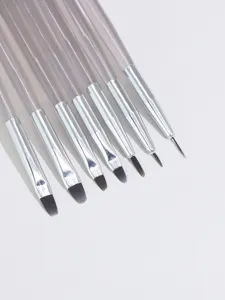 Detailed view of professional acrylic nail art brushes with fine tips for line drawing.