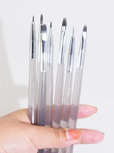 Detailed view of professional nail art brushes showing fine bristles and transparent handles