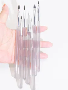 Detailed shot of professional nail art brushes set with clear acrylic handles for fine detailing.