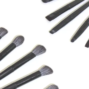 Primer plano detallado de pinceles de maquillaje de ojos profesionales con mango negro.