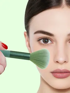 Green makeup brush detail view, soft bristles for smooth blush and powder application.