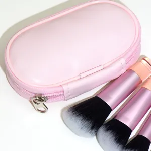 Detailed closeup product view of portable pink makeup pouch and cosmetic brush set.