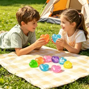 Kinderen spelen in de zonnige camping met kleurrijke glitter hart antistress speelgoed.