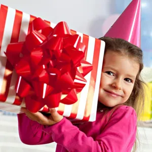 Detailed view of large red and white striped gift box with a giant red bow for parties.