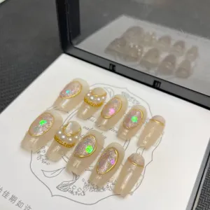 Unghie press-on fatte a mano con glitter lucidi, dettagli in foglia d'oro e perle.