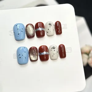 Vista dettagliata di unghie press-on fatte a mano con design di nail art blu e stella alla moda.