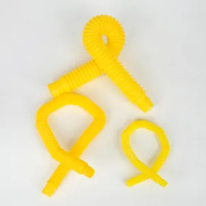 Yellow pop tube decompression toy detail view, flexible plastic stretch pipe for DIY fun.