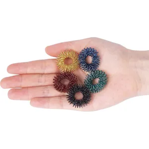 Nahaufnahme der bunten Metall-Sensorik-Fingerringe in der Hand mit feiner Federstruktur.