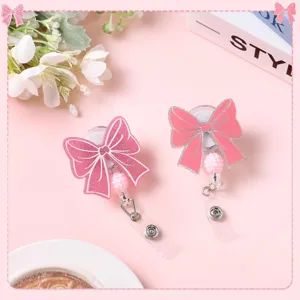 Acrylic pink bow badge reel with glitter beads, retractable key chain detail view for office use.