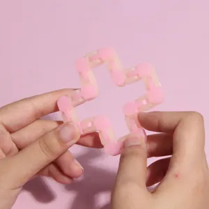 Jouet sensoriel piste fidget cliquetis rose, puzzle chaîne flexible détail dans la main.