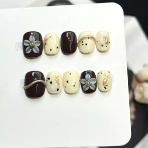 Set di unghie finte fatte a mano con design floreale e dettagli marroni per stile quotidiano.