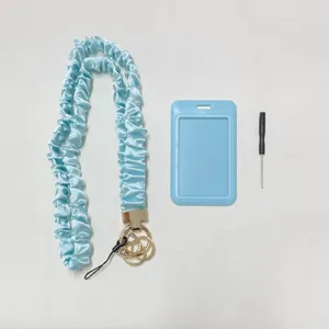 Detailansicht des hellblauen elastischen Stoffschlüsselbands, Ausweishalters und Werkzeugs.