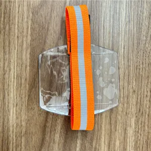 Detailansicht des transparenten Plastik-Armbandkartenhalters mit orangefarbenem Reflektorgurt.