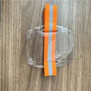 Nahaufnahme des transparenten Ausweishalters mit orangefarbenem reflektierenden Armband.