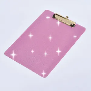 Vue détaillée de presse-papiers en acrylique pailleté rose, accessoire de bureau.