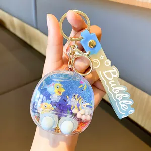 Detailed close-up of cute liquid water game keychain with vibrant cartoon fish design.