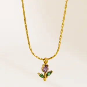 Detailed shot of the elegant gold-plated floral pendant necklace with purple and green stones.