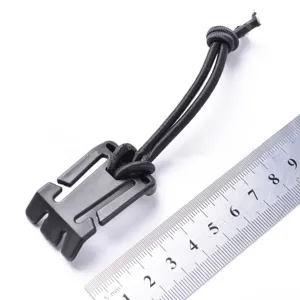 Detailed view of black plastic outdoor buckle with elastic cord and metal measuring ruler.